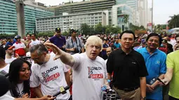 Walikota London, Boris Johnson (tengah) berbincang dengan Gubernur DKI Jakarta, Basuki Tjahaja Purnama (berkaos hitam) di kawasan Bundaran HI Jakarta, Minggu (30/11/2014). (Liputan6.com/Faizal Fanani)
