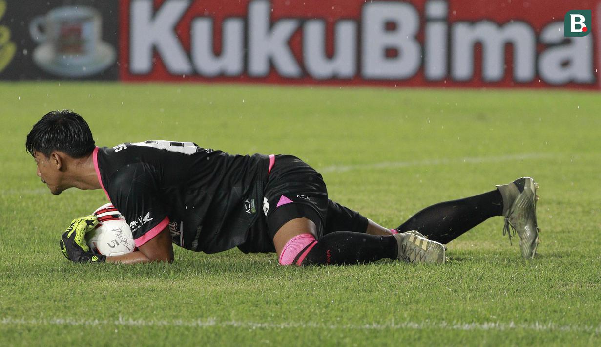 Kiper Persebaya Surabaya, Satria Tama menangkap bola saat menghadapi Persik Kediri dalam laga Grup C Piala Menpora 2021 di Stadion Si Jalak Harupat, Bandung, Selasa (23/3/2021). Persebaya menang 2-1 atas Persik. (Bola.com/M Iqbal Ichsan)