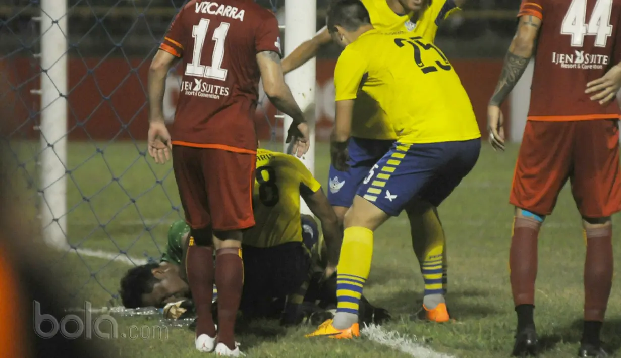 Kiper Persegres, Aji Saka terjatuh usai menghantam tiang gawang sebelah kanan saat melawan Arema FC pada Liga 1 2017 di Gresik, (12/7/2017). (Bola.com/Iwan Setiawan). 