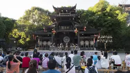 Para wisatawan menyaksikan pertunjukan di objek wisata Kota Furong di Wilayah Yongshun, Provinsi Hunan, China tengah (2/8/2020). Dengan menerapkan sejumlah langkah pencegahan epidemi, objek wisata tersebut mencatat peningkatan kunjungan turis selama liburan musim panas. (Xinhua/Chen Sihan)