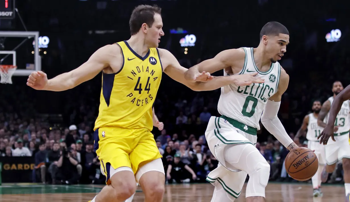 Pebasket Boston Celtics, Jayson Tatum, berusaha melewati pebasket Indiana Pacers, Bojan Bogdanovic,  pada laga NBA di TD Garden, Boston, Kamis (10/1). Celtics berhasil menang 135-108 atas Pacers. (AP/Charles Krupa)