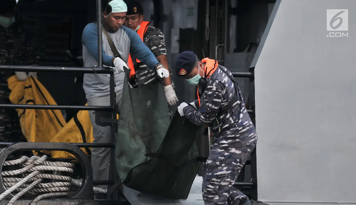 Anggota TNI menurunkan kantong berisi potongan tubuh korban jatuhnya pesawat Lion Air JT 610 dari KRI Torani saat tiba di posko evakuasi JICT 2, Tanjung Priok, Jakarta, Kamis (1/11). (Merdeka.com/Iqbal S. Nugroho)