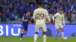 Pemain Al-Nassr, Cristiano Ronaldo, berusaha melewati pemain Al-Hilal pada laga Liga Arab Saudi 2022/202 di Stadion King Fahd, Rabu (19/4/2023). (Twitter Al-Nassr)