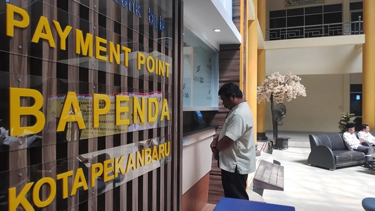 Seorang warga Pekanbaru membayar pajak di salah satu loket bank yang disediakan pemerintah setempat.