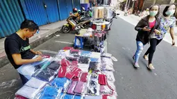 Pedagang menata masker berbahan kain di Pasar Pagi, Jakarta, Senin (6/4/2020). Penggunaan masker kain menjadi alternatif bagi warga yang sehat sebagai bagian proteksi diri dari ancaman virus. (Liputan6.com/Fery Pradolo)