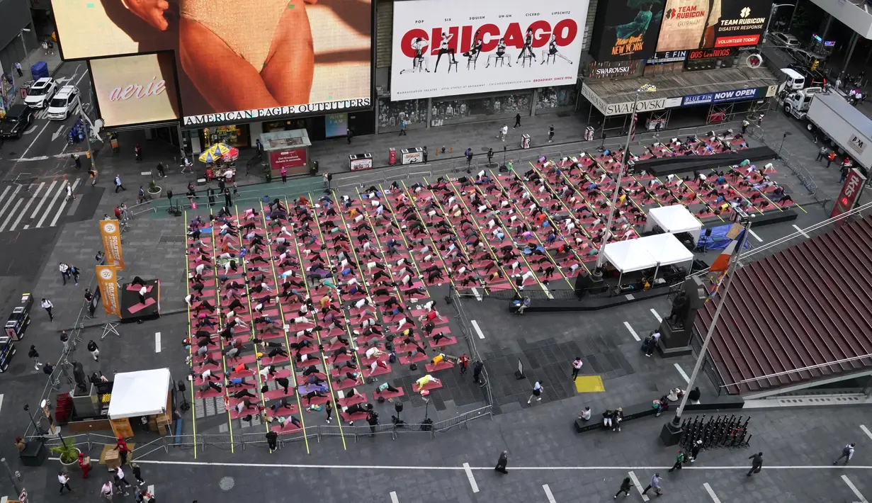 Acara ini dimulai 20 tahun yang lalu pada tanggal 21 Juni 2003, ketika tiga orang memutuskan untuk menggelar tikar mereka di Times Square untuk memberi hormat pada matahari terbit. (Photo by TIMOTHY A. CLARY / AFP)