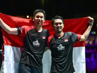 Pasangan Indonesia, Hendra Setiawan/Mohammad Ahsan melakukan selebrasi usai menjuarai Kejuaraan Dunia Bulutangkis 2019 setelah mengalahkan wakil Jepang, Takuro Hoki/Yugo Kobayashi, Minggu (25/8). Indonesia menang 25-23, 9-21, 21-15. (AFP/Fabrice Coffrini)