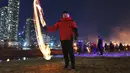 Seorang pria memutar kaleng arang yang terbakar selama acara "Jeongwol Daeboreum" atau (Perayaan Bulan Purnama) pertama tahun baru Imlek di taman tepi sungai di Seoul (17/2). (AFP Photo/Jung Yeon-je)