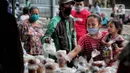 Warga mengambil takjil yang dibagikan di Jalan Cempaka Putih Raya, Jakarta, Senin (11/5/2020). Setiap hari selama Ramadan, masyarakat sekitar membagikan 350 takjil kepada warga kurang mampu dan terdampak virus corona COVID-19. (Liputan6.com/Johan Tallo)