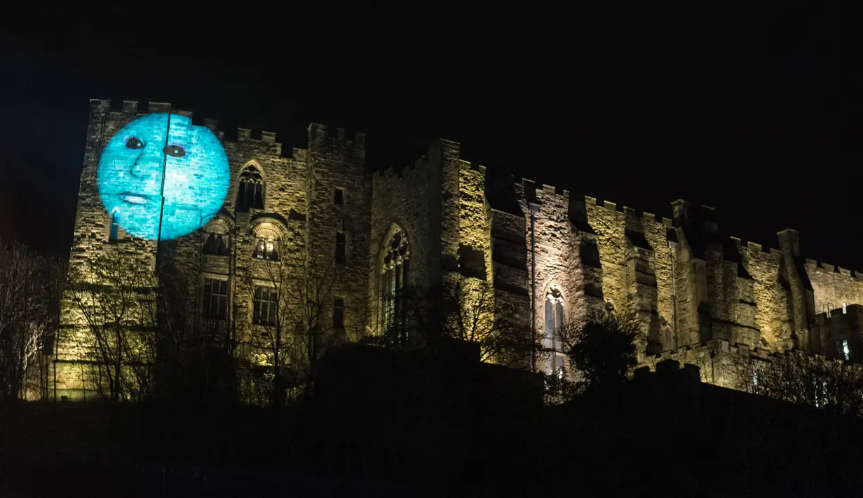 Sebuah instalasi seni berjudul 'Our Moon' oleh seniman Hannah Fox diproyeksikan ke dinding Kastil Durham selama Festival Cahaya Lumiere Durham di Inggris utara, 15 November 2017. (OLI SCARFF/AFP)