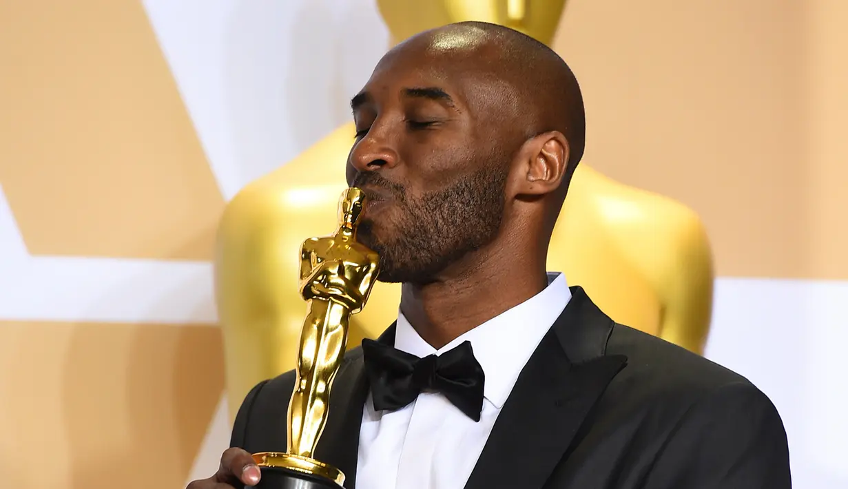 Kobe Bryant mencium Piala Oscar 2018 usai meraih penghargaan di Academy Awards ke-90 di Hollywood, California (3/4). Film animasi mengenai Kobe ini berhasil mengalahkan empat nominasi lainnya. (Jordan Strauss / Invision / AP)