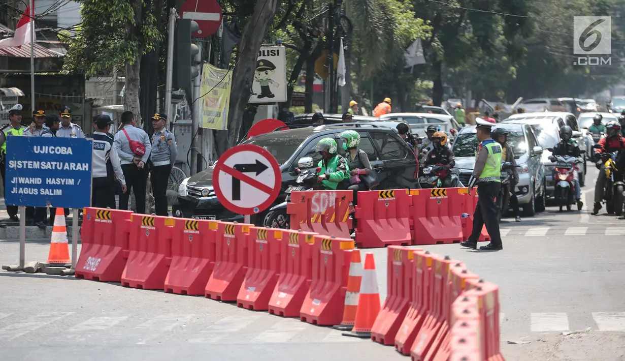 Petugas mengatur lalu lintas saat uji coba sistem satu arah (SSA) di Jalan KH Wahid Hasyim, Jakarta, Selasa (9/10). Sejumlah petugas terlihat berjaga di persimpangan menuju empat ruas jalan tersebut. (Liputan6.com/Faizal Fanani)