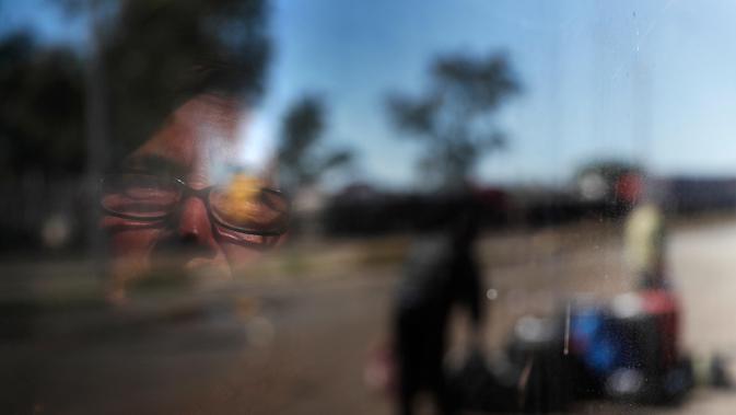 Orang tua Paraguay memandang ke luar jendela bus yang diorganisir khusus yang membawa orang-orang dari Buenos Aires, Argentina, ke kota perbatasan Puerto Falcon, Paraguay, tempat perbatasan ditutup sebagai langkah untuk mengekang penyebaran COVID-19, Jumat, 10 Juli 2020. (AP Photo/Jorge Saenz)