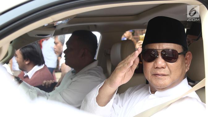 Bakal Calon Presiden, Prabowo Subianto melakukan gerakan hormat dari dalam mobilnya  saat perjalanan menuju Gedung KPU, Jakarta, Jumat (10/8). Ketua Umum Gerindra itu berangkat ke KPU untuk mendaftarkan diri sebagai capres. (Liputan6.com/Herman Zakharia)