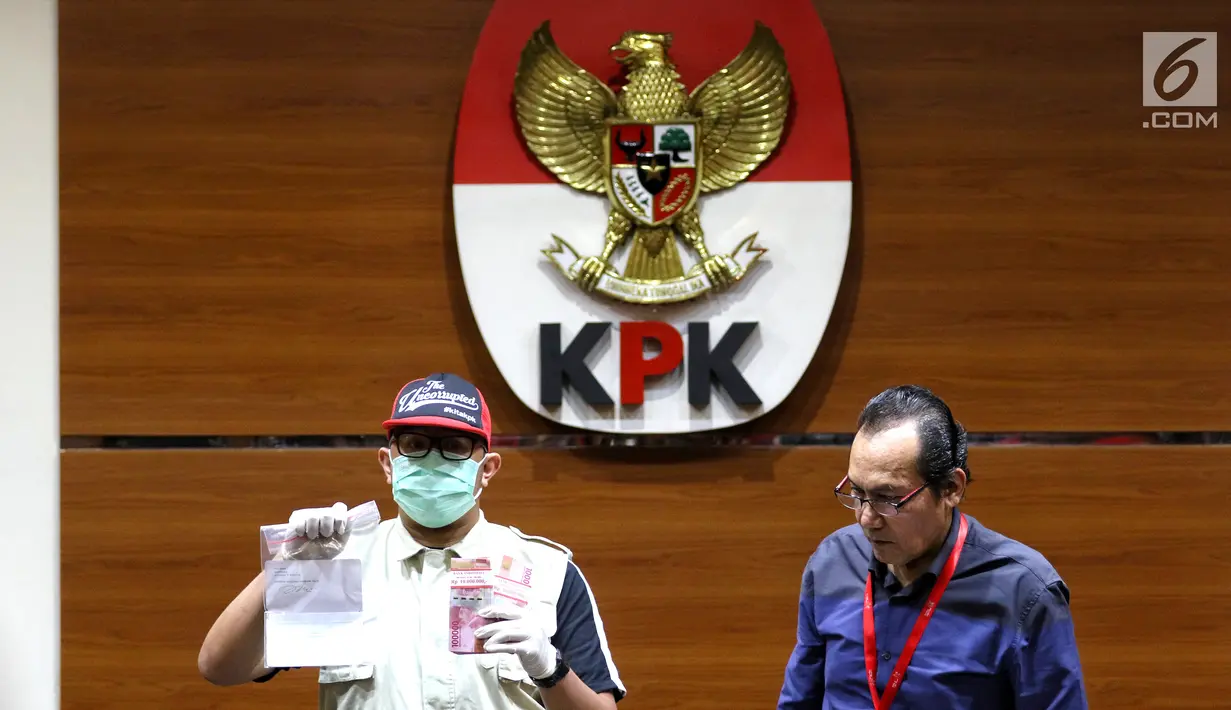 Petugas dan Wakil Ketua KPK Saut Situmorang menunjukkan barang bukti OTT Direktur Teknologi PT Krakatau Steel, Wisnu Kuncoro terkait pengadaan barang dan jasa tahun 2019 di Gedung KPK, Jakarta, Sabtu (23/3). KPK menangkap 4 tersangka dengan barang bukti uang Rp 20 juta. (Liputan6.com/Johan Tallo)