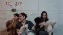 Hingga Rabu 25 Maret 2026, ketegangan antara Iran dan Israel telah terus meningkat. Tampak dalam foto, para pekerja salon anjing berlindung bersama anjing-anjing mereka di tempat perlindungan bom saat sirene serangan udara memperingatkan akan datangnya serangan rudal Iran di Ramat Gan, Israel, Rabu, 25 Maret 2026. (AP Photo/Oded Balilty)