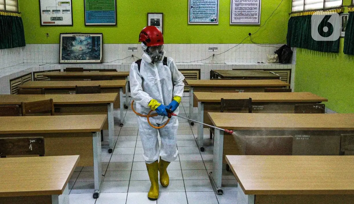 Petugas PMI menyemprotkan disinfektan di salah satu ruang SMPN 97 Jakarta, Kamis (3/2/2022). Pemerintah Provinsi DKI Jakarta mengeluarkan kebijakan untuk memberhentikan PTM di tengah melonjaknya kasus COVID-19 di DKI Jakarta. (Liputan6.com/Faizal Fanani)