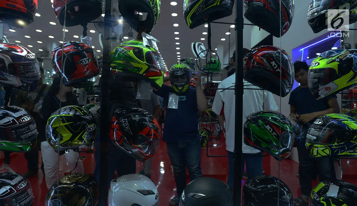 Pengunjung melihat-lihat helm yang dipajang salah satu produsen pada pameran di Jakarta Fair atau Pekan Raya Jakarta 2019 di JIExpo Kemayoran, Jumat (7/6/2019). Jakarta Fair Kemayoran menjadi salah satu tujuan warga ibukota untuk menikmati libur Lebaran. (merdeka.com/Imam Buhori)