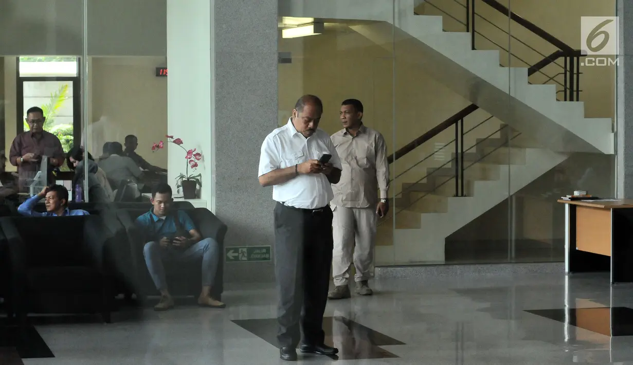 Anggota DPR RI, Melchias Marcus Mekeng melihat ponselnya usai diperiksa di Gedung KPK Jakarta, Kamis (10/8). Melchias Marcus Mekeng diperiksa sebagai saksi TPK pengadaan paket penerapan KTP elektronik. (Liputan6.com/Helmi Fithriansyah) 
