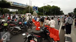 Sejumlah motor terparkir akibat penutupan Jalan Medan Merdeka Timur saat ribuan massa ormas melakukan unjuk rasa di Bareskrim Polri, Gedung KKP Jakarta, Jumat (14/10). (Liputan6.com/Helmi Fithriansyah)