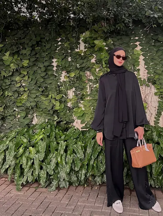 Tampil serba hitam, Paula padukan kemeja lengan gelembung, celana hijab, dengan kerudung lilit. Ditutup dengan kacamata hitam, loafers dan tas Hermes [@paula_verhoeven]