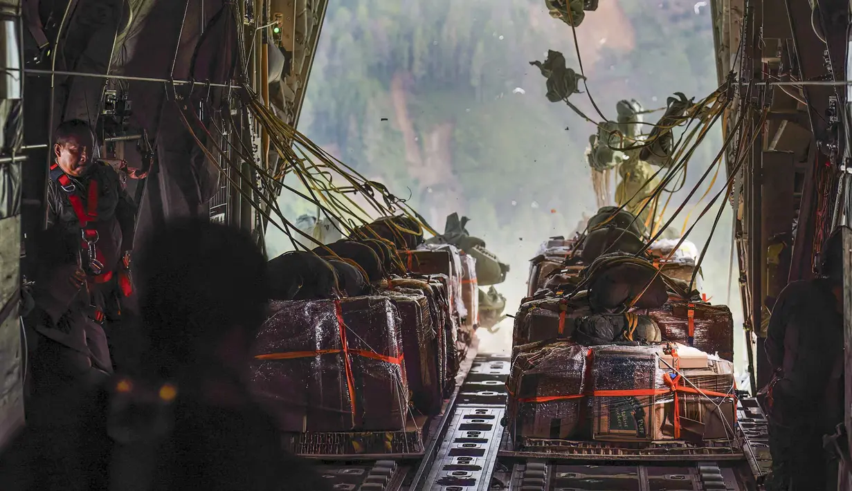Distribusi bantuan logistik menjadi prioritas utama untuk memenuhi kebutuhan dasar masyarakat terdampak. Tampak dalam foto, personel Tentara Nasional Indonesia (TNI) Angkatan Udara (AU) menyaksikan bantuan dijatuhkan dari ruang kargo pesawat angkut militer di wilayah Gayo Lues, Aceh, yang terdampak banjir dan terisolasi pada Minggu 7 Desember 2025. (HENDRA SYAMHARI/AFP)