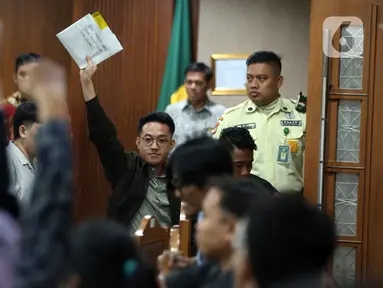 Delpedro Marhaen mengangkat tangan usai mengikuti sidang lanjutan dugaan penghasutan kerusuhan pada Agustus 2025 di Pengadilan Negeri Jakarta Pusat, Kamis (8/1/2026). Majelis Hakim Pengadilan Negeri Jakarta Pusat membacakan putusan sela kasus dugaan penghasutan kerusuhan pada Agustus 2025. (Liputan6.com/Helmi Fithriansyah)