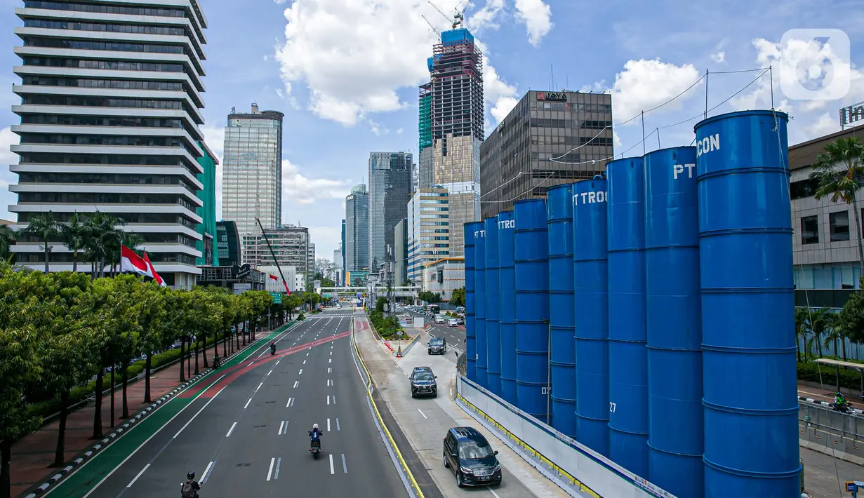 Sejumlah kendaraan melintas disamping proyek pembangunan MRT fase dua di Jalan MH Thamrin, Jakarta, Senin (22/3/2021). Dishub DKI Jakarta akan memberlakukan rekayasa lalu lintas di sekitaran pembangunan jalur MRT fase dua yang dimulai pada hari ini. (Liputan6.com/Faizal Fanani)