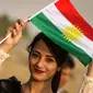 Seorang gadis Kurdi Iran memegang bendera Kurdi saat mengampanyekan referendum untuk kemerdekaan di kota Bahirka, Irak Utara (21/9). Mereka meminta referendum untuk menentukan kemerdekaan etnis Kurdi di Irak. (AFP Photo/Safin Hamed)