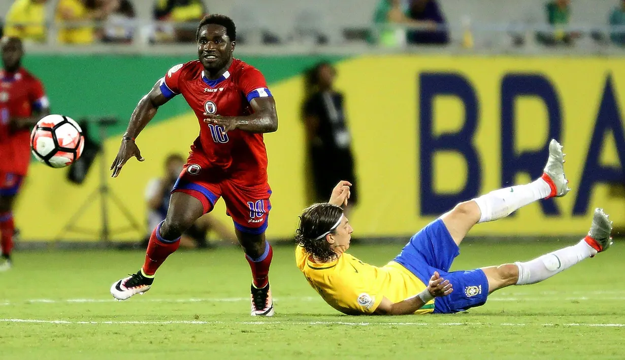 Pemain Haiti, Jeff Louis (kiri) merebut bola dari pemain Brasil, Filipe Luis pada penyisihan grup B Copa America Centenario 2016 di Orlando, Florida, AS, (9/6/2016) WIB. Brasil menang 7-1. (AFP/ Gregg Newton)