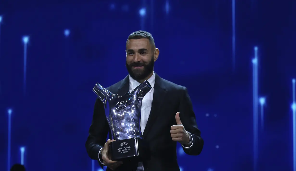 Penyerang Real Madrid, Karim Benzema memegang trofi sebagai Pemain  Terbaik Eropa 2021-2022 dalam upacara pengundian Liga Champions di Istanbul, Turki, Kamis (25/8/2022). Penampilan luar biasa Benzema bersama Real Madrid di musim lalu membuatnya layak meraih gelar individu prestisius tersebut. (AP Photo/Emrah Gurel)