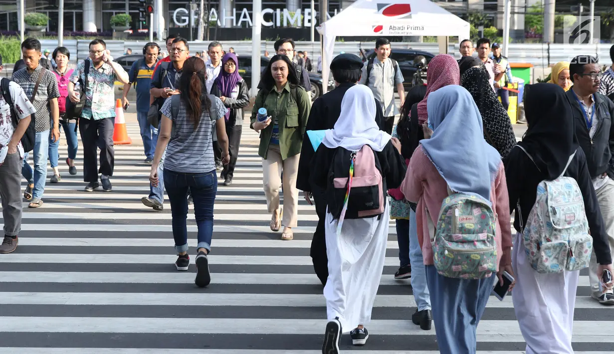 Warga melintasi Pelican Crossing di sekitar Halte Transjakarta Gelora Bung Karno, Jakarta, Jumat, (30/11). Penyeberangan pelican crossing diberlakukan selama revitalisasi jembatan penyeberangan orang (JPO) berlangsung. (Liputan6.com/Helmi Fithriansyah)