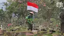 Petugas Pertamanan dan Kehutanan Kota Jakarta Pusat mengenakan atribut kemerdekaan saat memotong rumput di TPU Karet Bivak, Jakarta, Minggu (16/8/2020). Para petugas bekerja dengan mengenakan atribut kemerdekaan dalam rangka menyambut HUT ke-75 RI. (Liputan6.com/Herman Zakharia)
