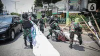 Anggota TNI mencopot paksa baliho Rizieq Shihab yang terpasang di sekitar kawasan Petamburan, Jakarta, Jumat (20/11/2020). Pencopotan dilakukan karena menyalahi aturan yang telah ditetapkan. (Liputan6.com/Faizal Fanani)