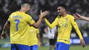 Pemain Al Nassr, Cristiano Ronaldo (kiri), melakukan selebrasi dengan Ali Lajami setelah dirinya mencetak gol ke gawang Al Shabab dalam laga perempat final King's Cup Arab Saudi 2023 yang digelar di Al Shabab Club Stadium, Selasa (12/12/2023) dini hari WIB. (AFP/Str)