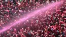 Umat Hindu India disemprot dengan cairan berwarna dalam festival keagamaan Holi di Kuil Swupramayan Kalupur, Ahmedabad, Rabu (20/3). Walaupun Holi merupakan festival Hindu, namun seluruh penduduk India merayakannya. (SAM PANTHAKY / AFP)