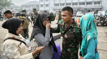 Salah satu anggota keluarga menangis saat seorang prajurit berpamitan sebelum menaiki KRI Teluk Ratai 509 di Dermaga Mako Kolinlamil, Jakarta, Rabu (27/1). 1300 prajurit diberangkatkan menjaga perbatasan darat RI-Malaysia. (Liputan6.com/Faizal Fanani)