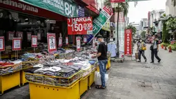 Pengunjung melihat pakaian yang dijajakan di salah satu tenant di Pasar Baru, Jakarta, Rabu (5/4/2021). Selama pandemi COVID-19, tak banyak orang yang mau berbelanja di luar rumah. (Liputan6.com/Faizal Fanani)