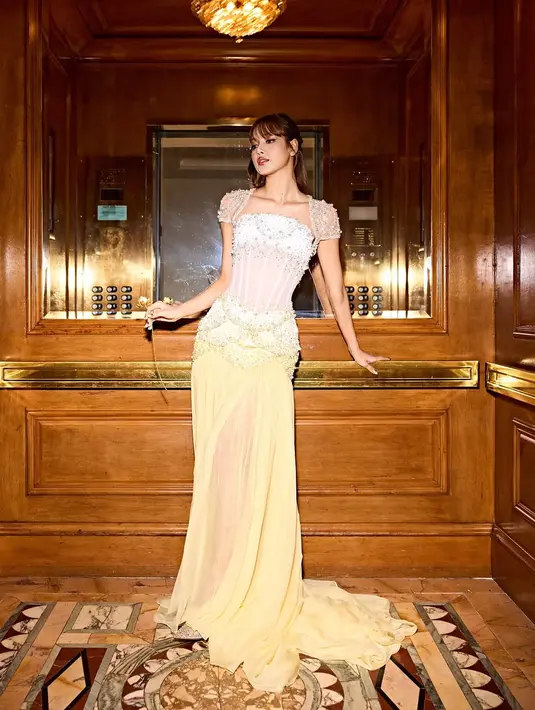 Lisa BLACKPINK tampil ala princess belle dengan gaun sheer korset bernuansa putih dan kuning pastel [@lalalalisa_m]