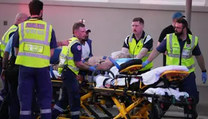 Petugas saat mengevakuasi seorang korban dalam insiden penembakan di Pantai Bondi, Sydney, Minggu, 14 Desember 2025. (Foto: AP/Mark Baker)