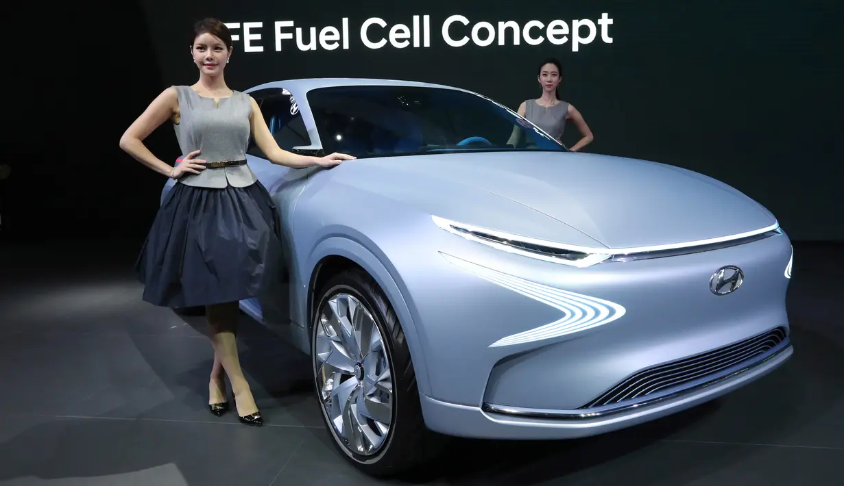 Dua model berpose di dekat mobil Hyundai Motor's FE Fuel Cell Concept selama acara Seoul Motor Show di Goyang, Seoul, Korea Selatan, Kamis (30/3). Sekitar 27 merek menunjukkan mobil terbaru mereka dan konsep. (AP Photo / Lee Jin-man)