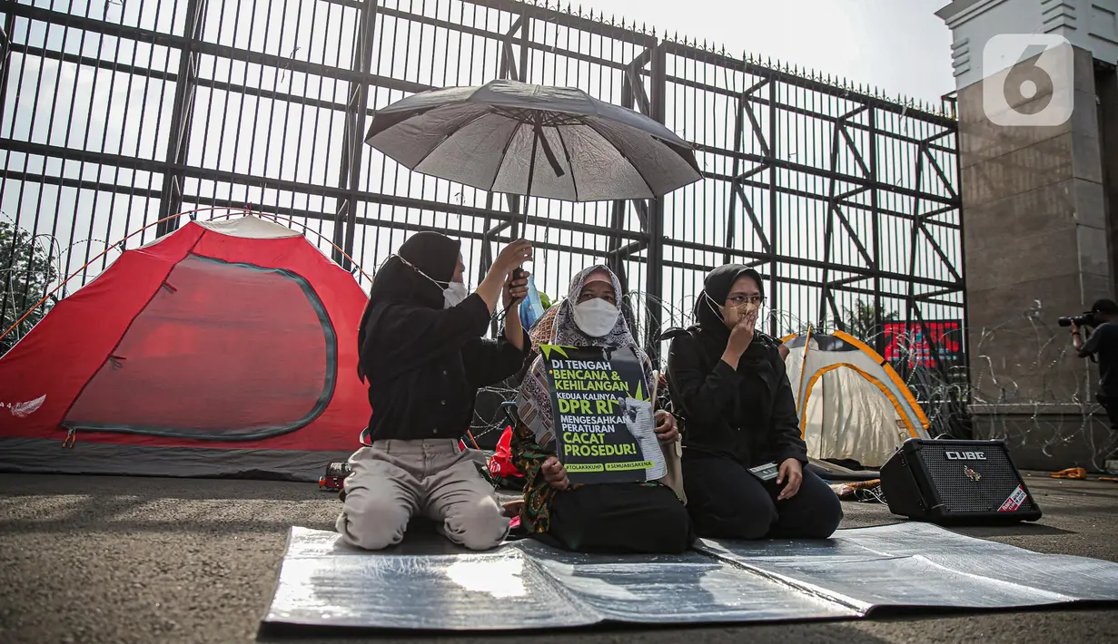Sejumlah aktivis dari gabungan elemen masyarakat berunjuk rasa di depan Kompleks Parlemen, Senayan, Jakarta, Selasa(6/12/2022). Mereka menolak pengesahan Rancangan Kitab Undang-Undang Hukum Pidana (RKUHP). (Liputan6.com/Faizal Fanani)