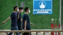 Orang-orang yang mengenakan masker berjalan melewati barikade di luar hotel karantina virus corona COVID-19 dengan tanda bertuliskan "Hotel pemantauan kesehatan perumahan terpusat - masuk tanpa izin sangat dilarang" di Beijing, China, 15 Juni 2022. (AP Photo/Mark Schiefelbein)