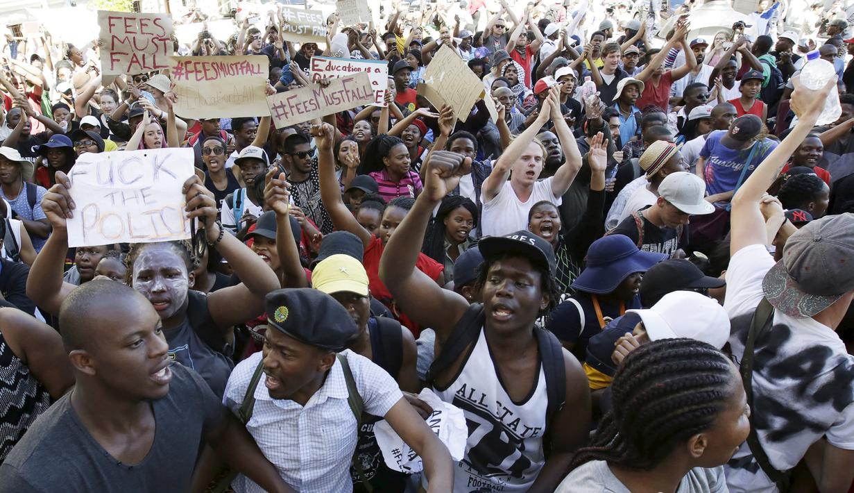 Pelajar membawa poster saat demonstrasi di luar Parlemen Afrika Selatan di Cape Town, Rabu (21/10). Polisi anti huru hara menembakkan gas airmata kepada ratusan pelajar yang berdemonstrasi menentang rencana kenaikan uang sekolah. (REUTERS/Mark Wessels)