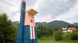 Sebuah patung kayu yang menyerupai Donald Trump didirikan di Sela pri Kamniku, kawasan utara Slovenia, 30 Agustus 2019. Patung Trump setinggi 8 meteritu mengenakan setelan biru, kemeja berwarna putih, dasi merah, serta mengangkat tangan seperti Patung Liberty. (AP/Darko Bandic)