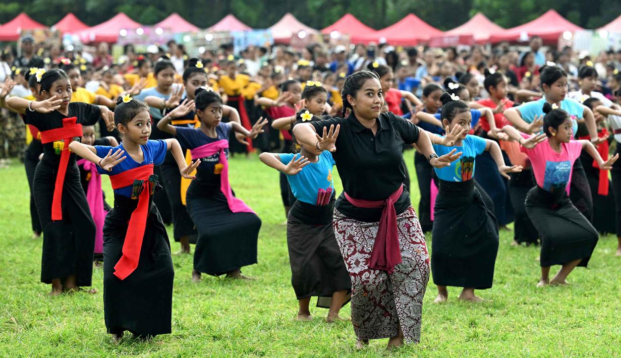 Ratusan anak-anak menari menampilkan kesenian tari tradisional seperti Janger dan tari kreasi lainnya. Tampak dalam foto, anak-anak menampilkan tarian tradisional untuk menyambut malam pergantian tahun di Bali, pada Rabu 31 Desember 2025. (SONNY TUMBELAKA/AFP)