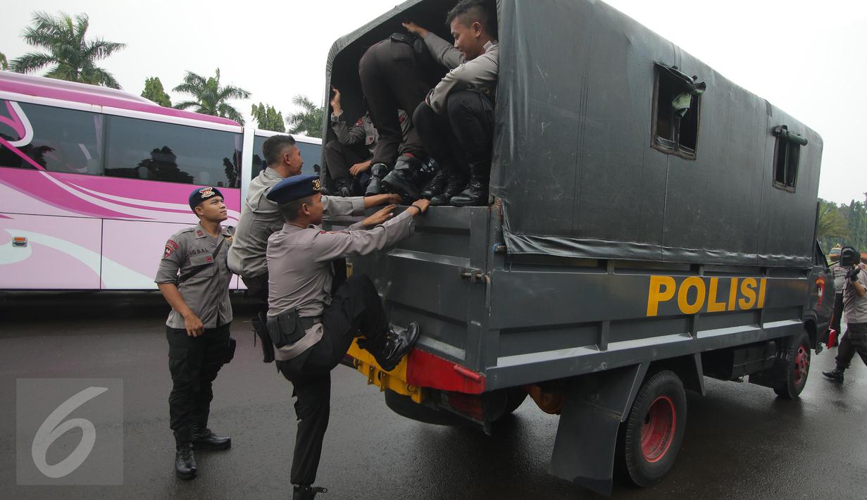 Petugas kepolisian menaiki truk pengangkut saat melakukan pengamanan di kawasan Monas, Jakarta, Selasa (18/4). Polda Metro Jaya dan Kodam Jaya mengerahkan 64.523 personel gabungan untuk mengawal Pilkada DKI 2017 putaran kedua. (Liputan6.com/Faizal Fanani)