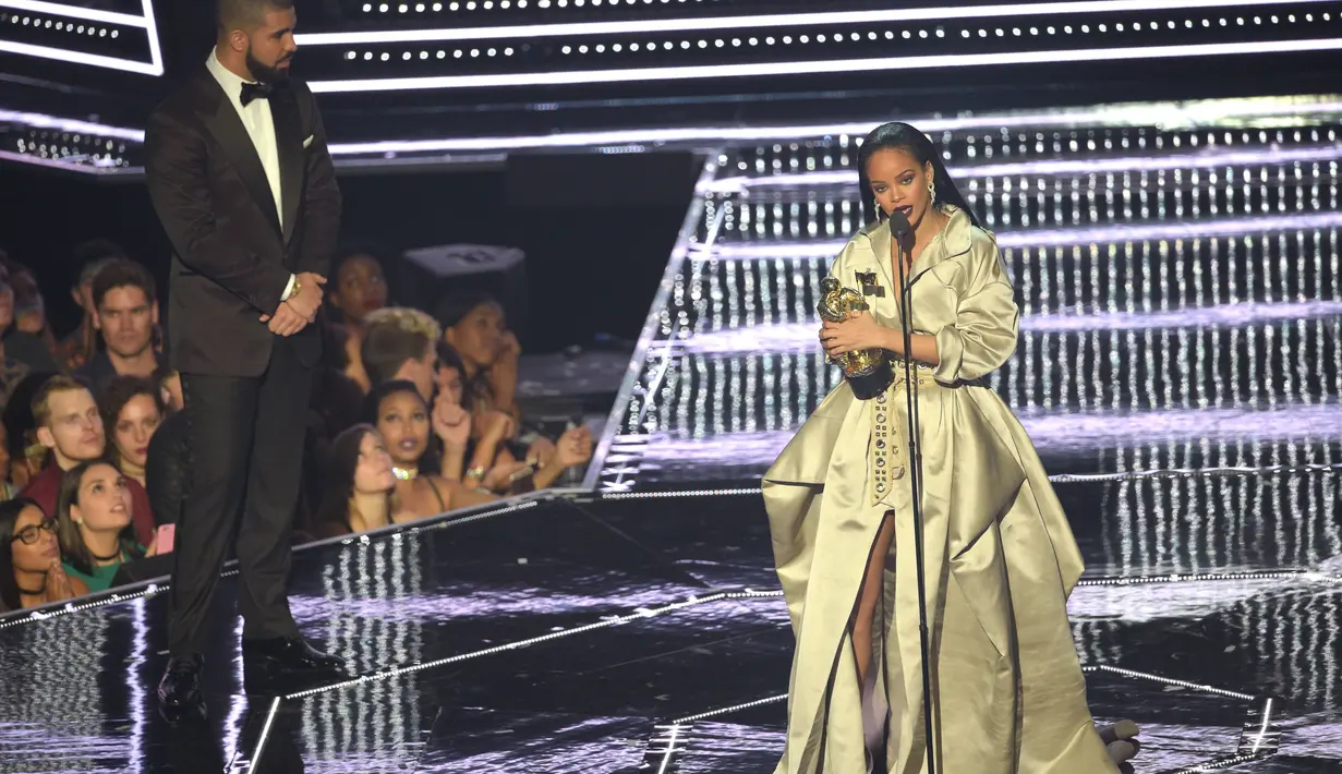 Setelah itu ia memberikan piala. Ciuman singkat diberikan di atas panggung dengan disaksikan oleh ribuan pasang mata. Keduanya juga berpelukan diatas panggung. (AFP/Bintang.com)