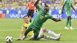 Pemain Senegal, Sadio Mane (depan) jatuh saat berebut bola dengan pemain Kolombia, Mateus Uribe pada laga terakhir grup H di Samara Arena, Samara, Rusia, (28/6/2018). Kolombia menang 1-0. (AP/Martin Meissner)