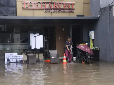 Pekerja membersihkan pertokoan yang terendam banjir di Kawasan Bendungan Hilir (Benhil), Jakarta Pusat, Selasa (25/2/2020). Salah satu wilayah terdampak banjir yakni kawasan Benhil hingga membuat akses jalan untuk sementara terputus.  (Liputan6.com/Angga Yuniar)